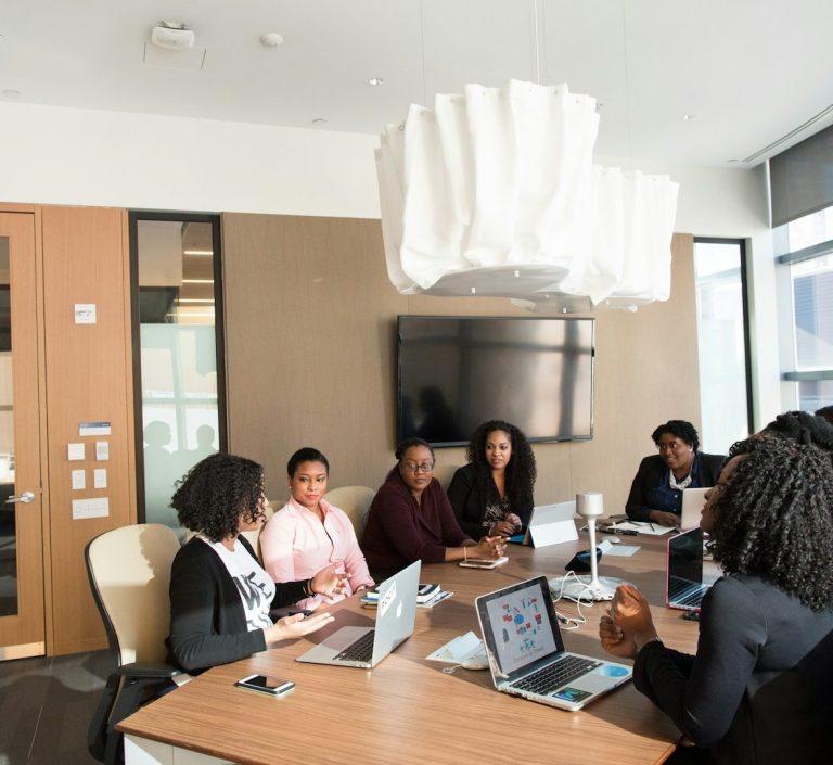 Professionelles Dolmetschen bei Meetings – klare Verständigung in multikulturellen Teams Mehrere Personen in einem modernen Besprechungsraum bei einem Business-Meeting mit Laptops – Symbol für Dolmetschen in Konferenzen